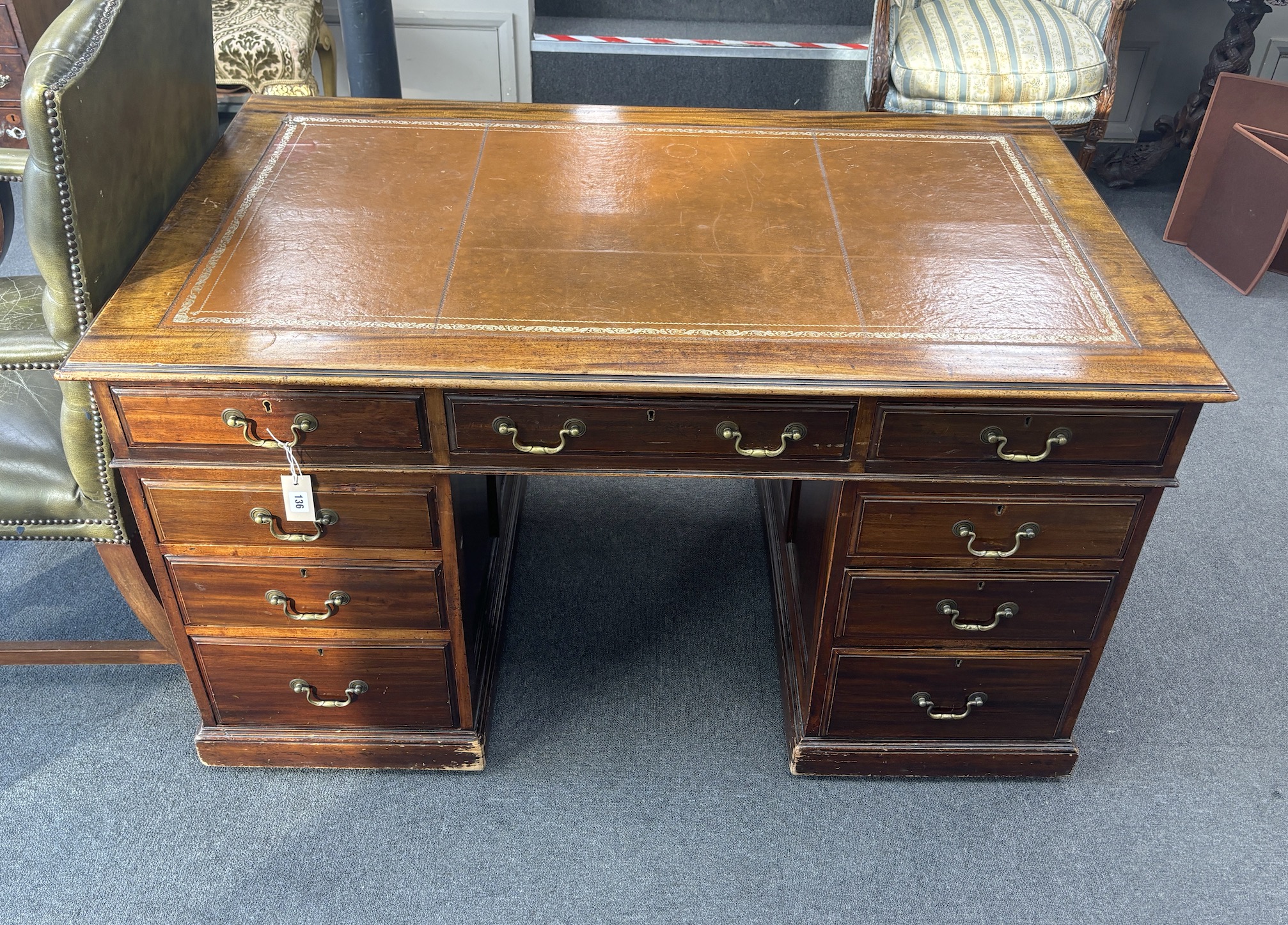 A George III style mahogany pedestal desk, width 138cm, depth 83cm, height 77cm together with a Gainsborough style buttoned green leather elbow chair